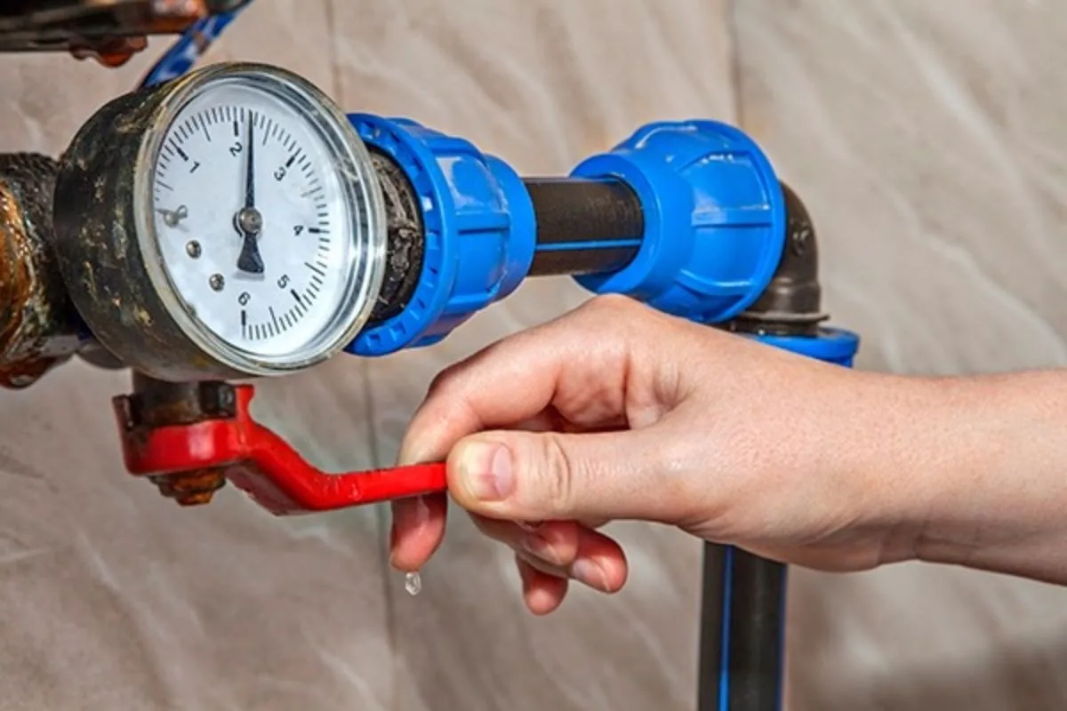 Main water shutoff valve being closed on an exterior wall