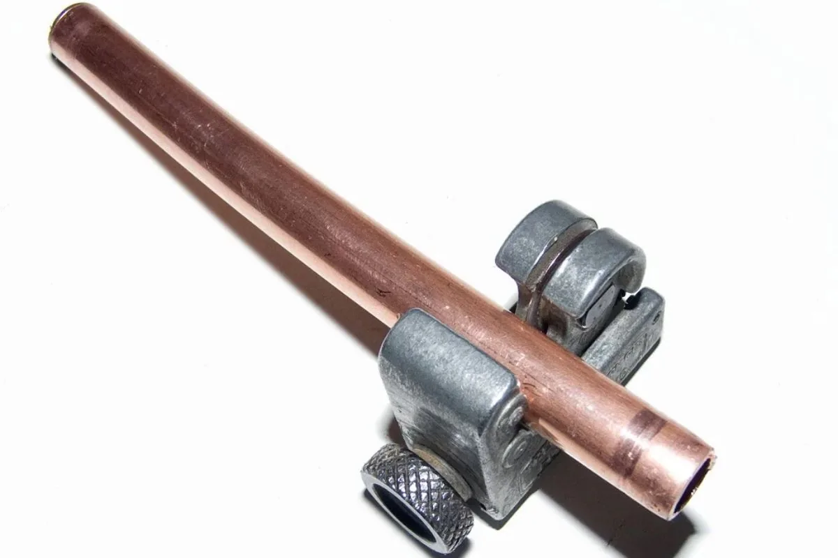 Split copper pipe beside a new fitting during a burst pipe repair