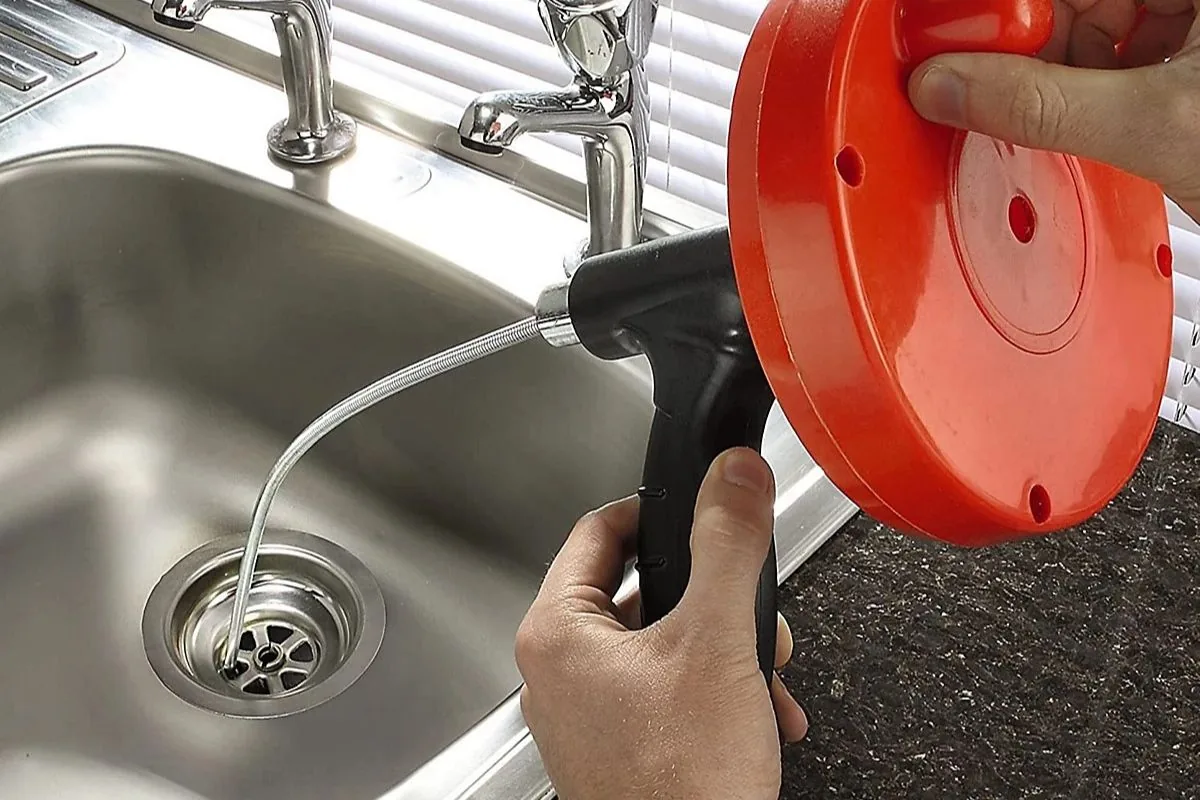 Drain auger entering a kitchen sink drain